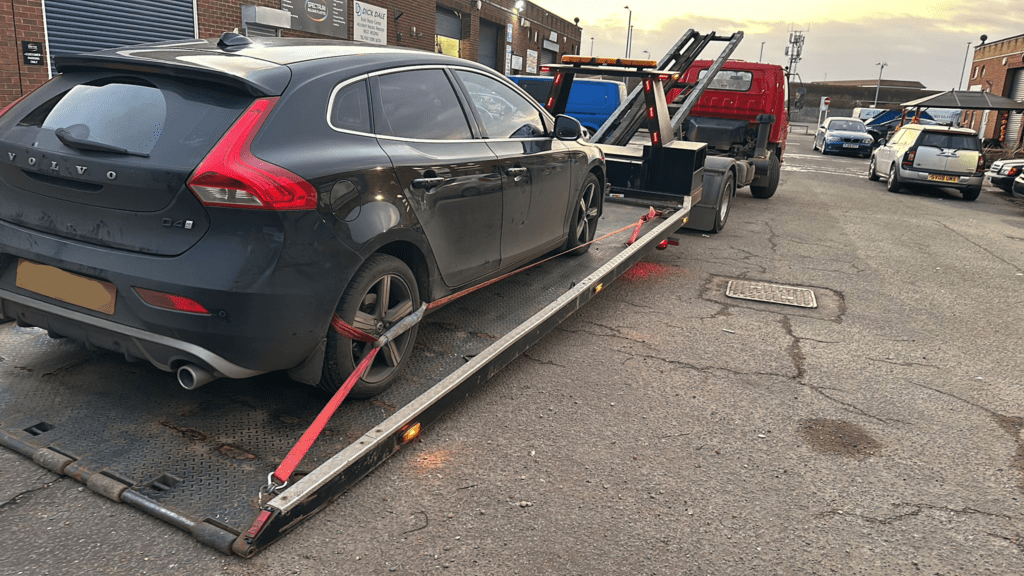 Car being pulled onto a truck during winch recovery in Warwickshire